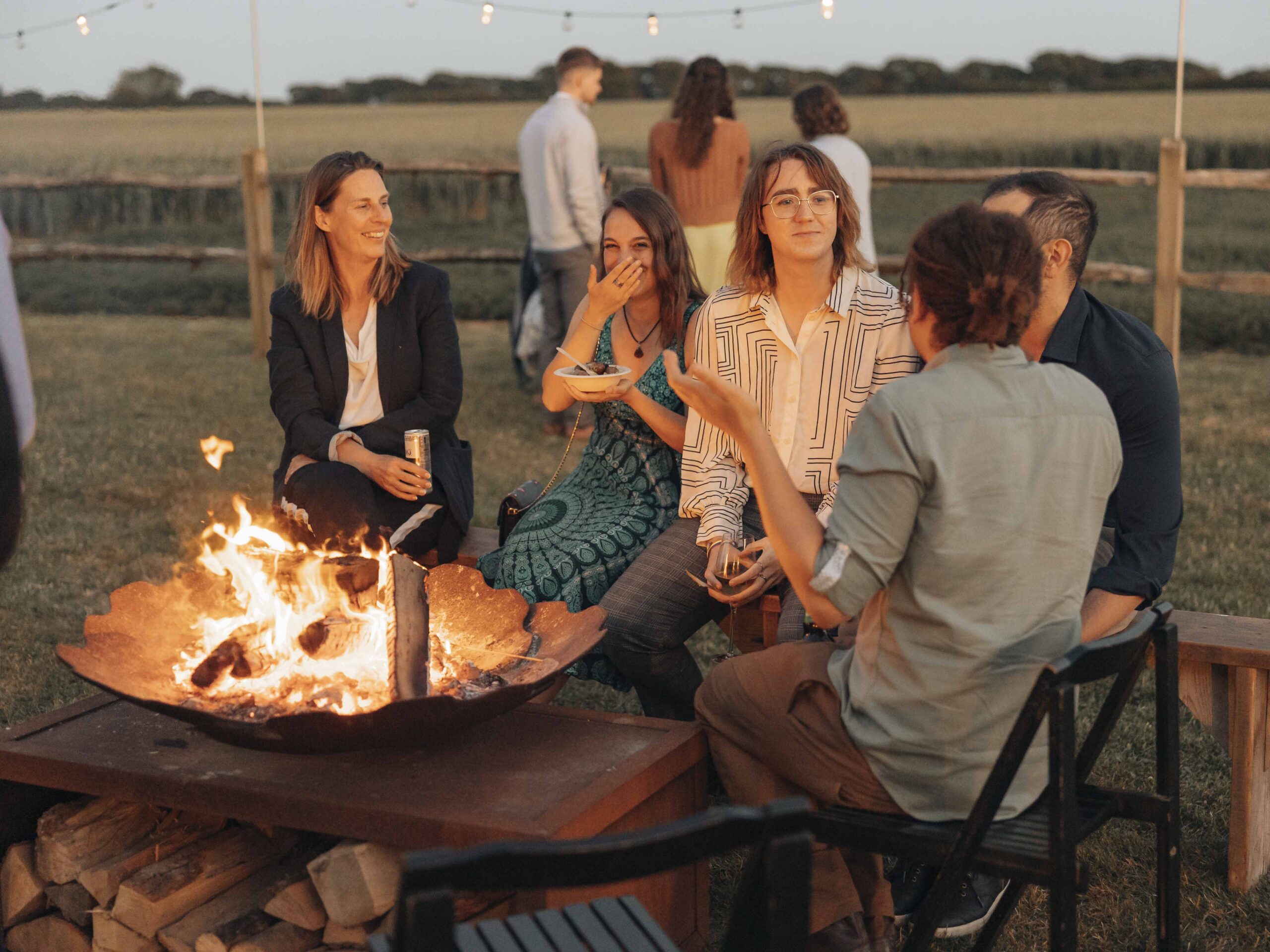 Wedding guests laughing by the fire