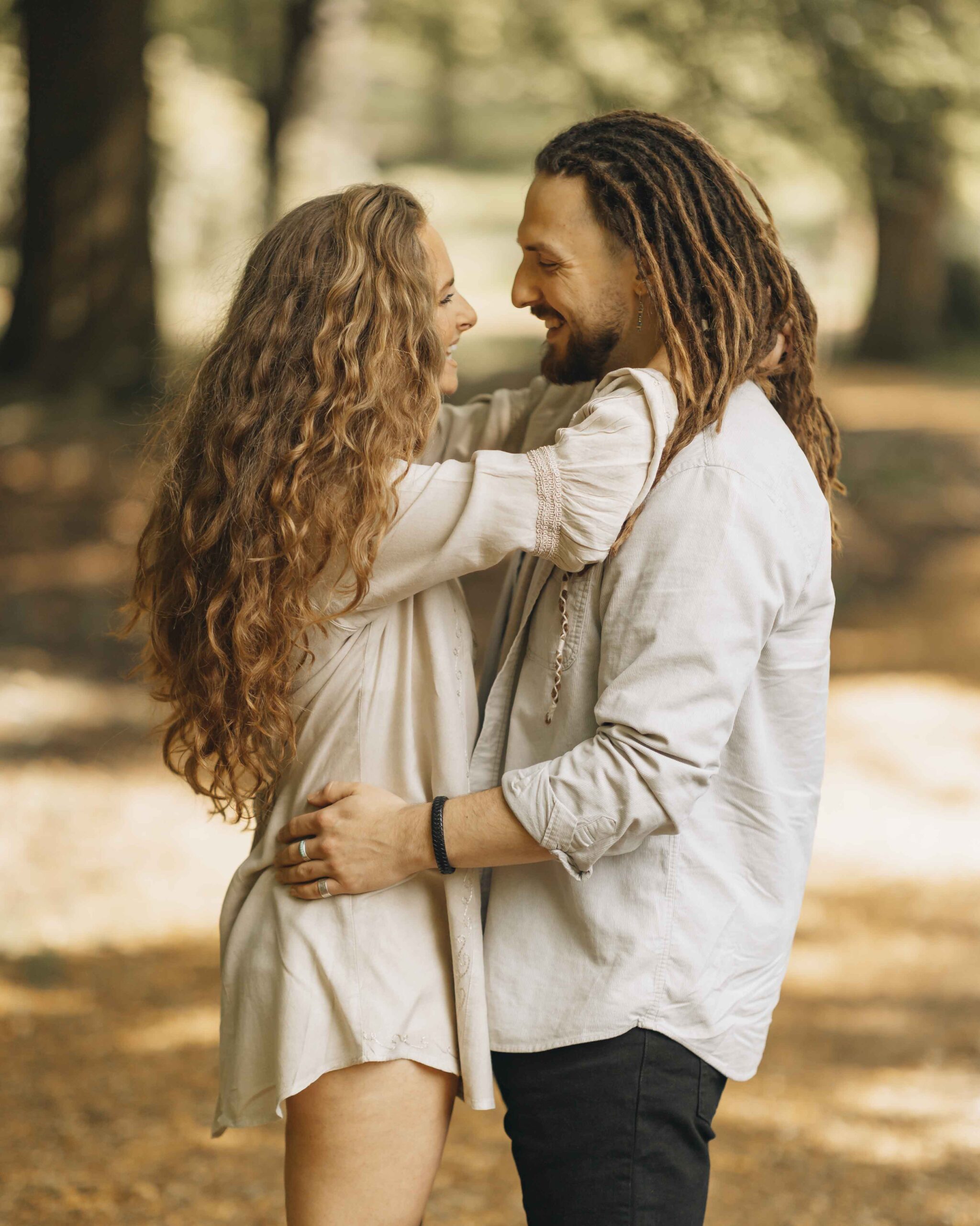 couple embracing and laughing in the woods